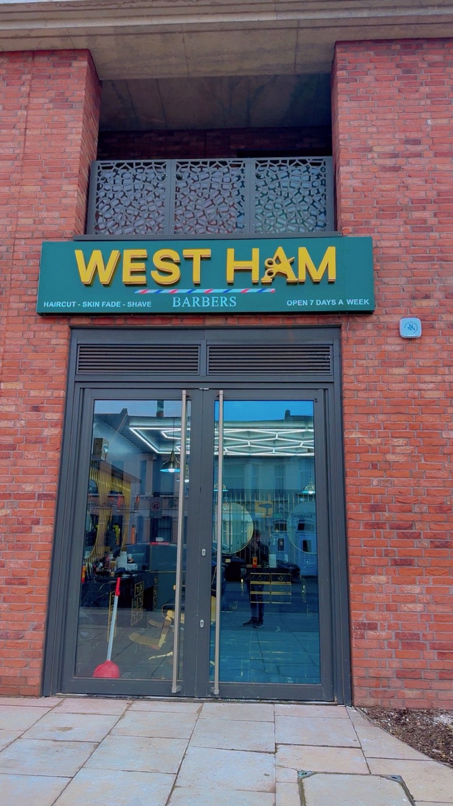 Barber giving a haircut inside West Ham Barbers