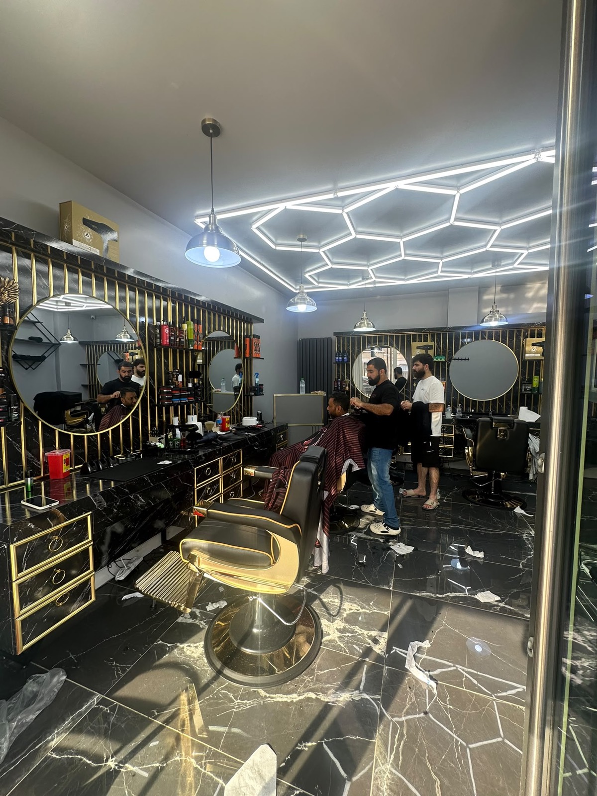 West Ham Barbers interior with gold barber chair and marble counters